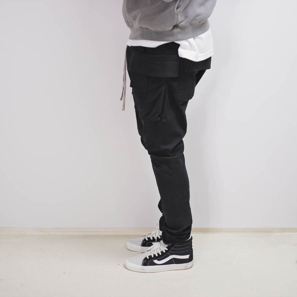 Slim Cargo Pant in black, side view with sneakers.