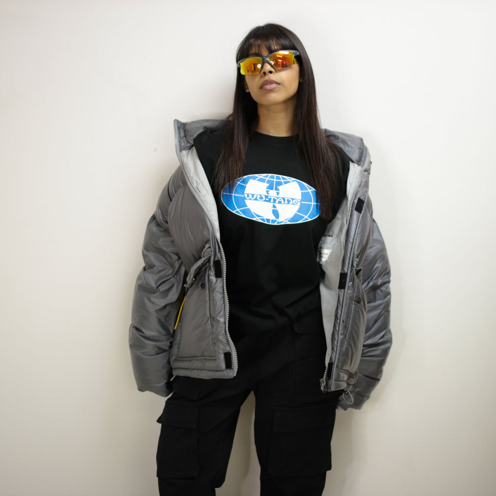 Model wearing a Padded Round Jacket with sunglasses, featuring a globe graphic t-shirt underneath.