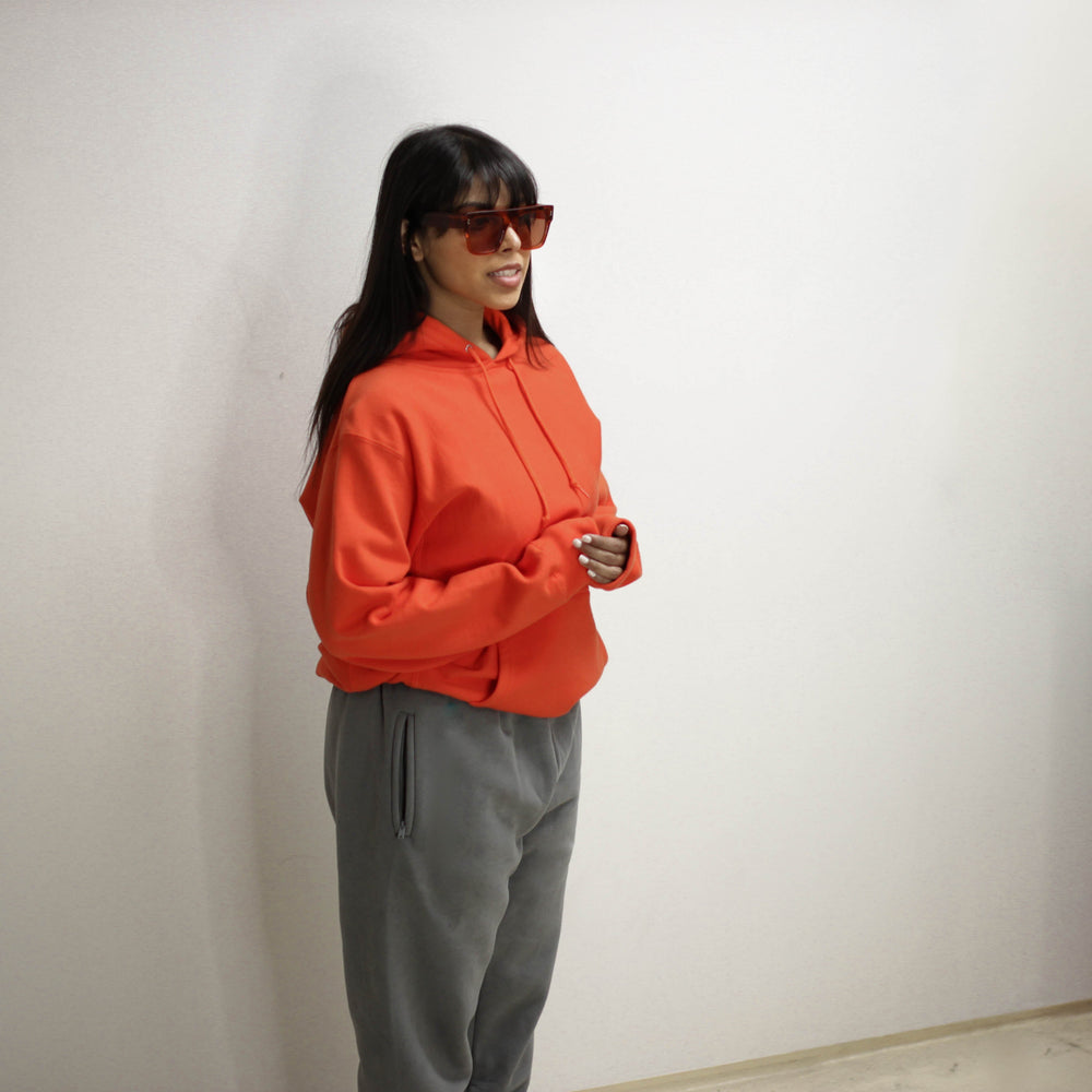 Woman wearing an orange infrared hoodie with sunglasses.