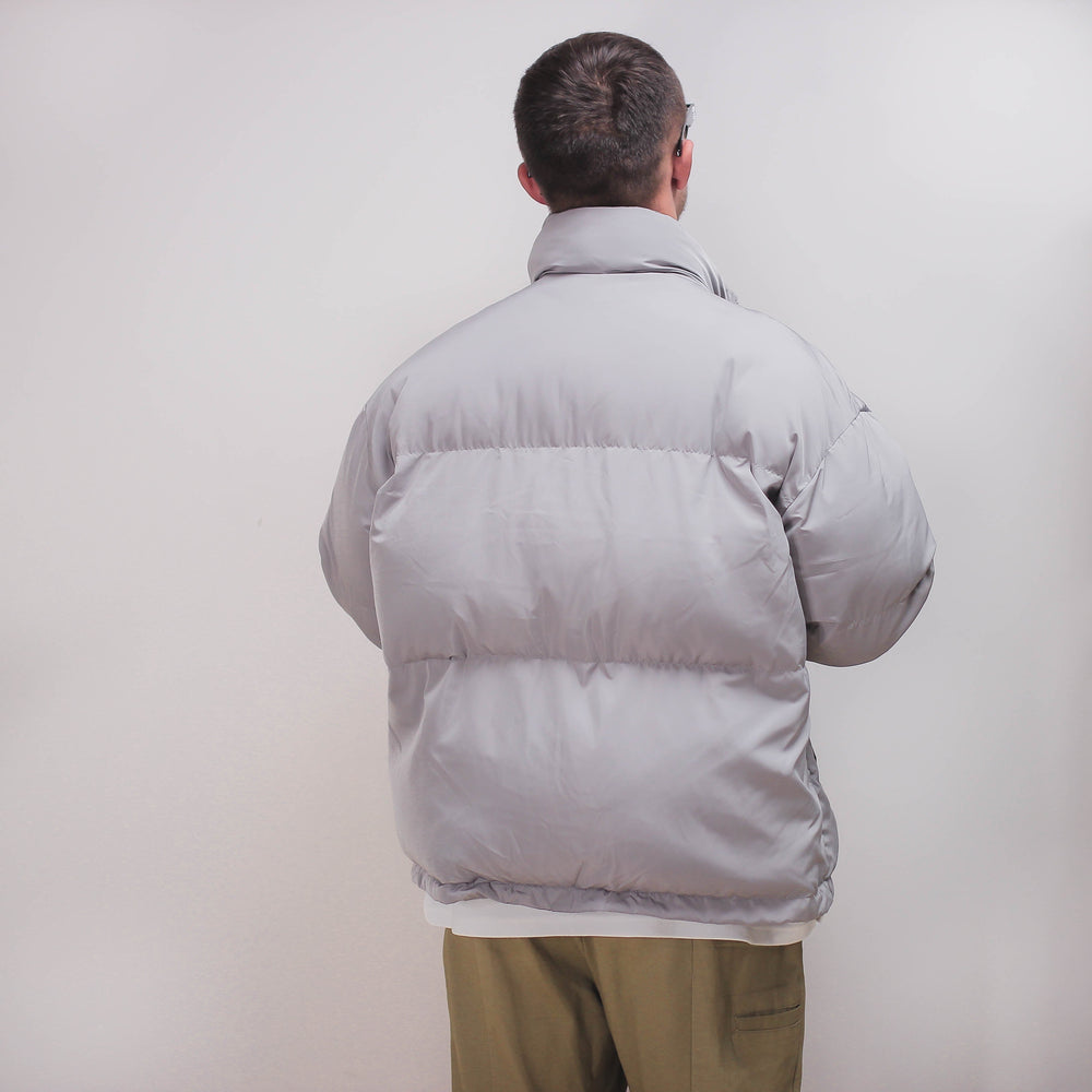 Gray puff jacket worn by a person, viewed from the back.