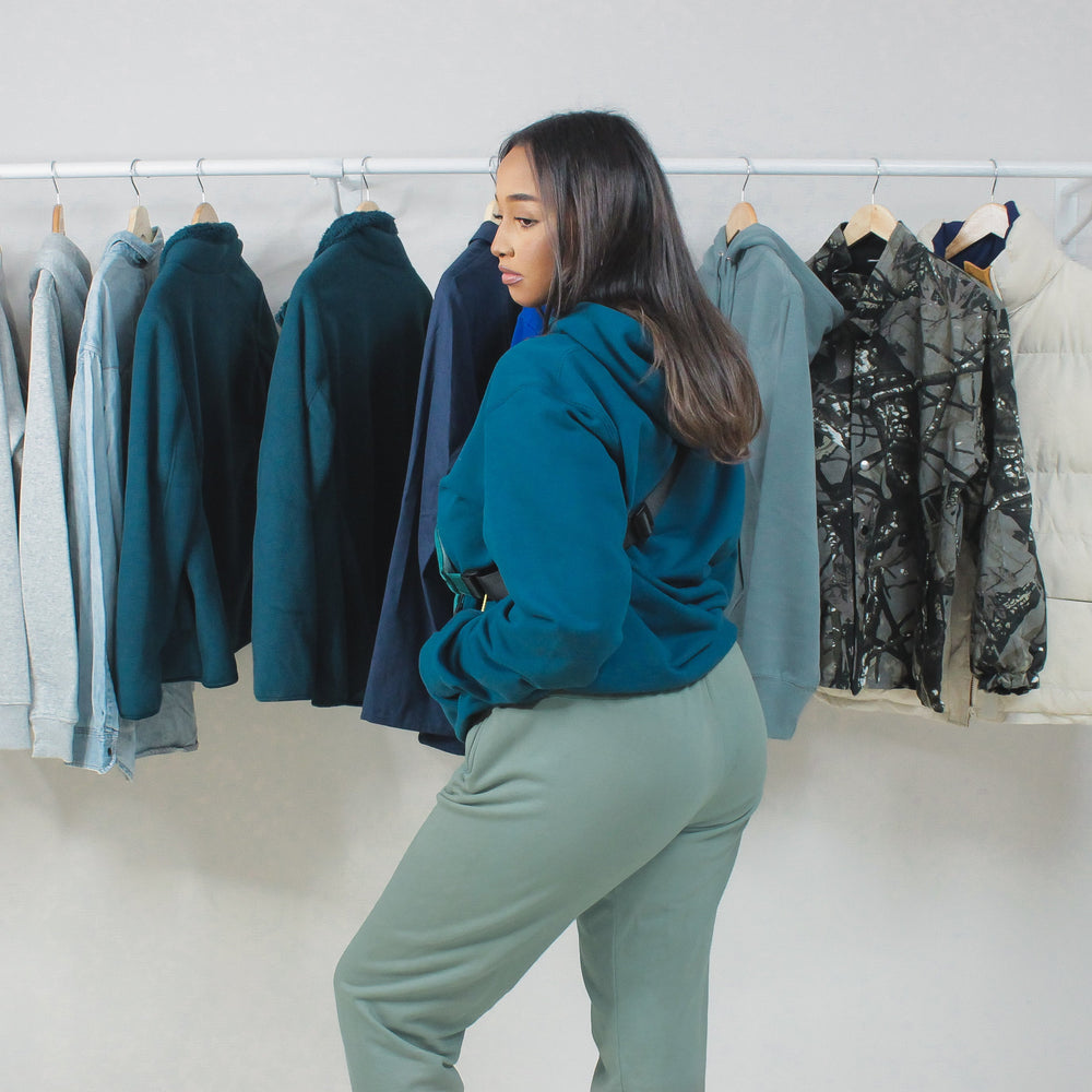 Woman wearing a Sapphire Blue hoodie in a clothing store.