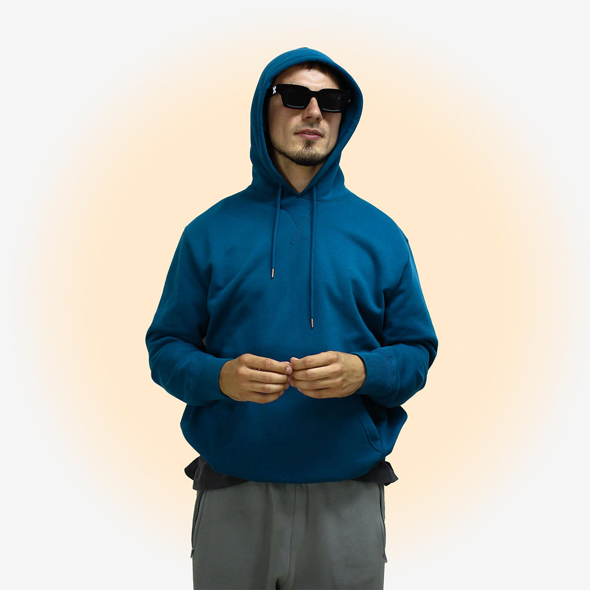 Man wearing a sapphire blue hoodie with hood up.