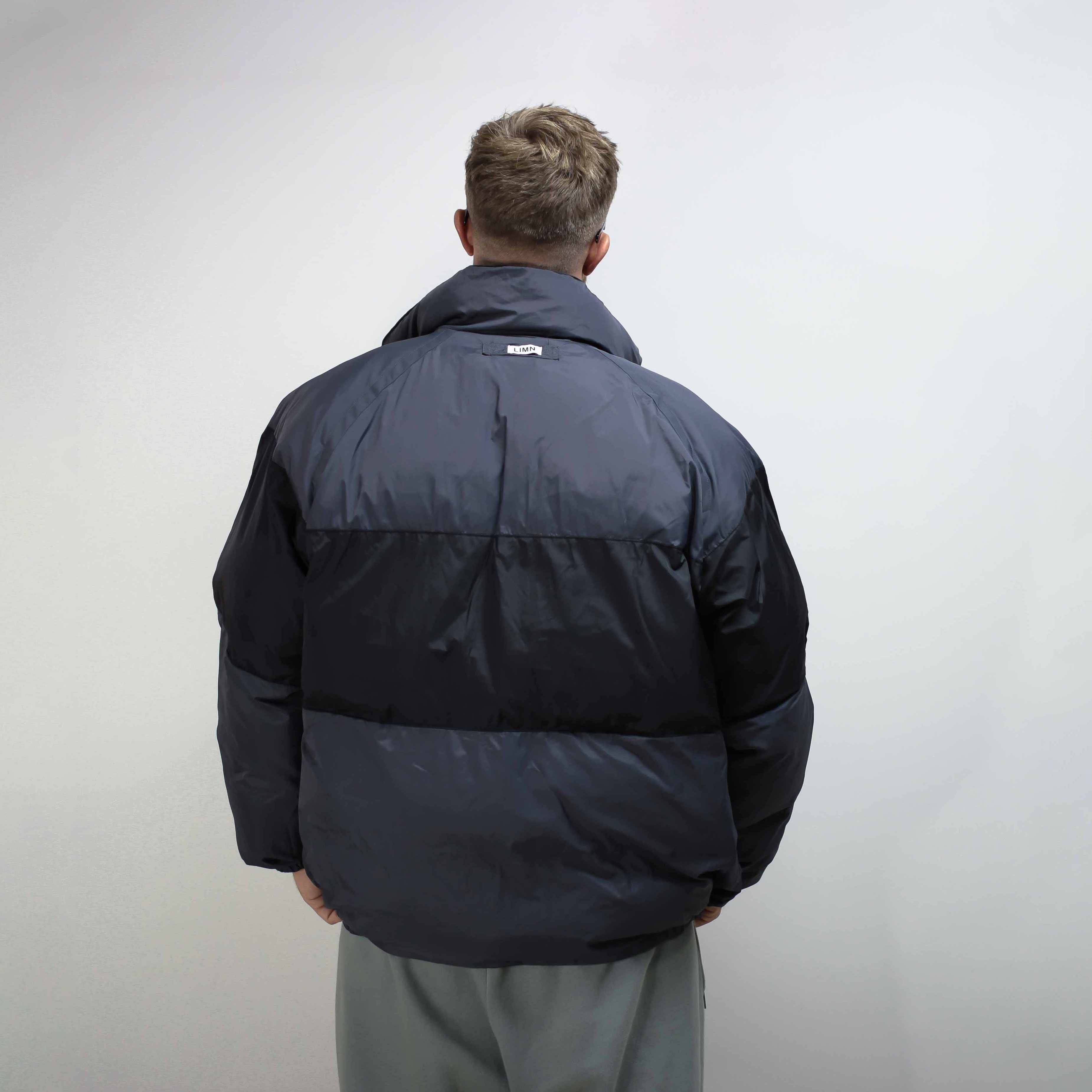 Rear view of a black flight jacket worn by a person.