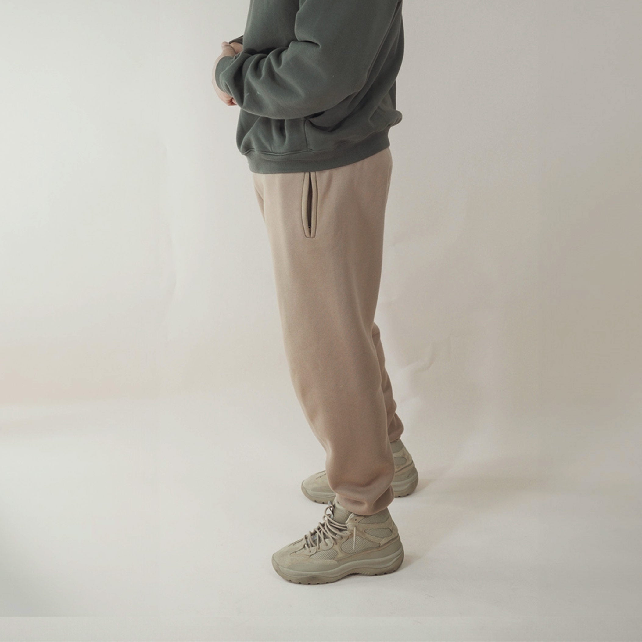 Tan Premium Joggers on person with green sweater and beige sneakers.