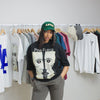 female model with range of hanging clothes in background, green limn clothing hat, black t-shirt with vintage pink-floyd graphic, ash joggers