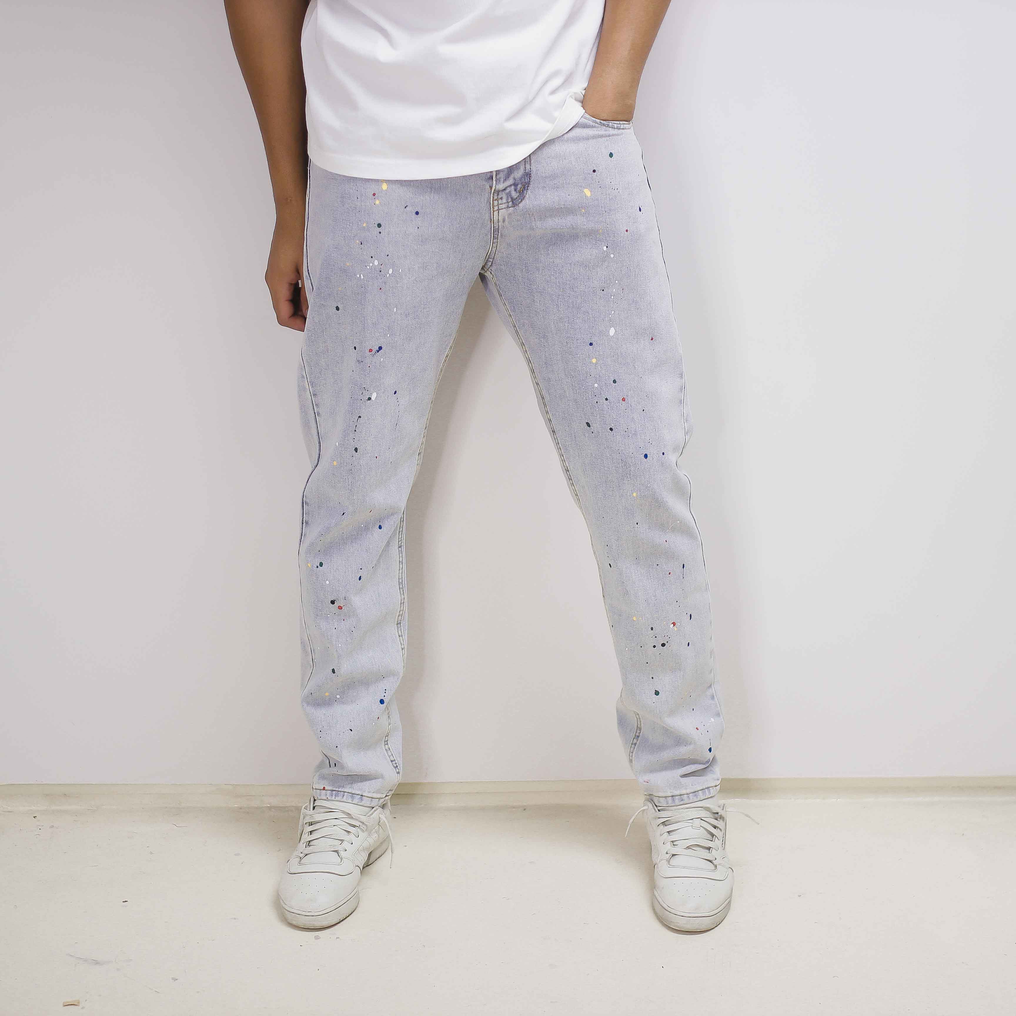 Light-blue denim jeans with paint splatter, relaxed fit, and slightly loose cuffs.