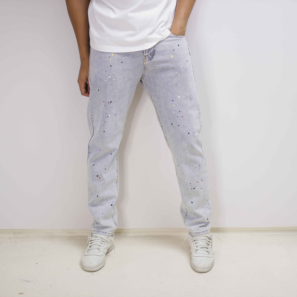 Light-blue denim jeans with paint splatter, relaxed fit, and slightly loose cuffs.