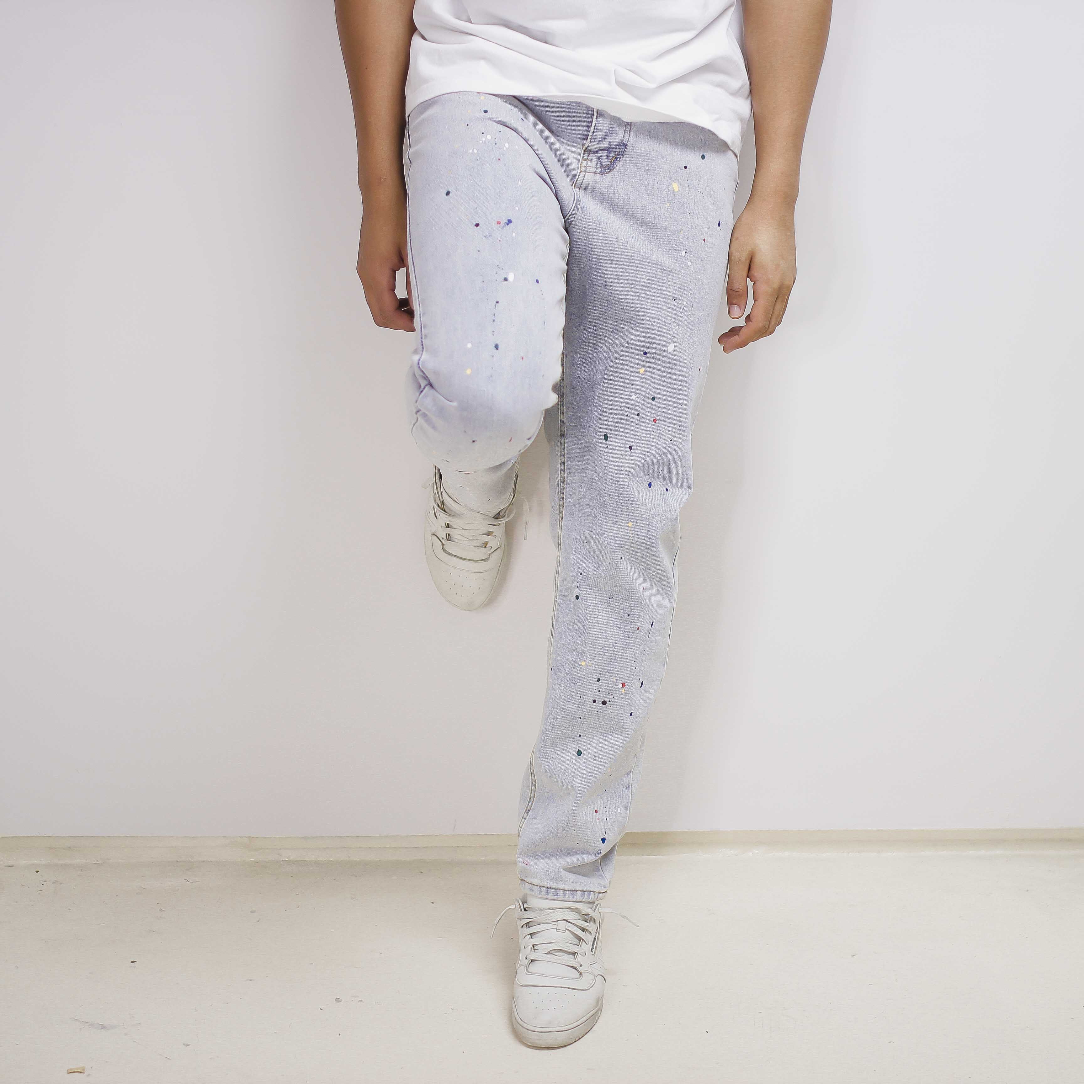 Light-blue paint splatter denim jeans with a relaxed, distressed look and looser fit.