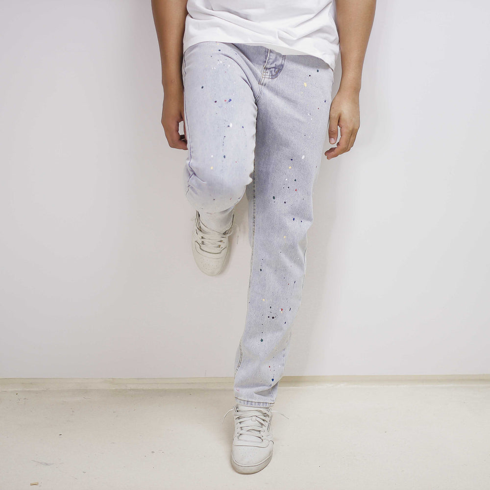 Light-blue paint splatter denim jeans with a relaxed, distressed look and looser fit.