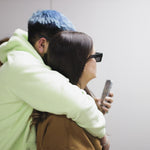 Two people wearing a double layer hoodie.