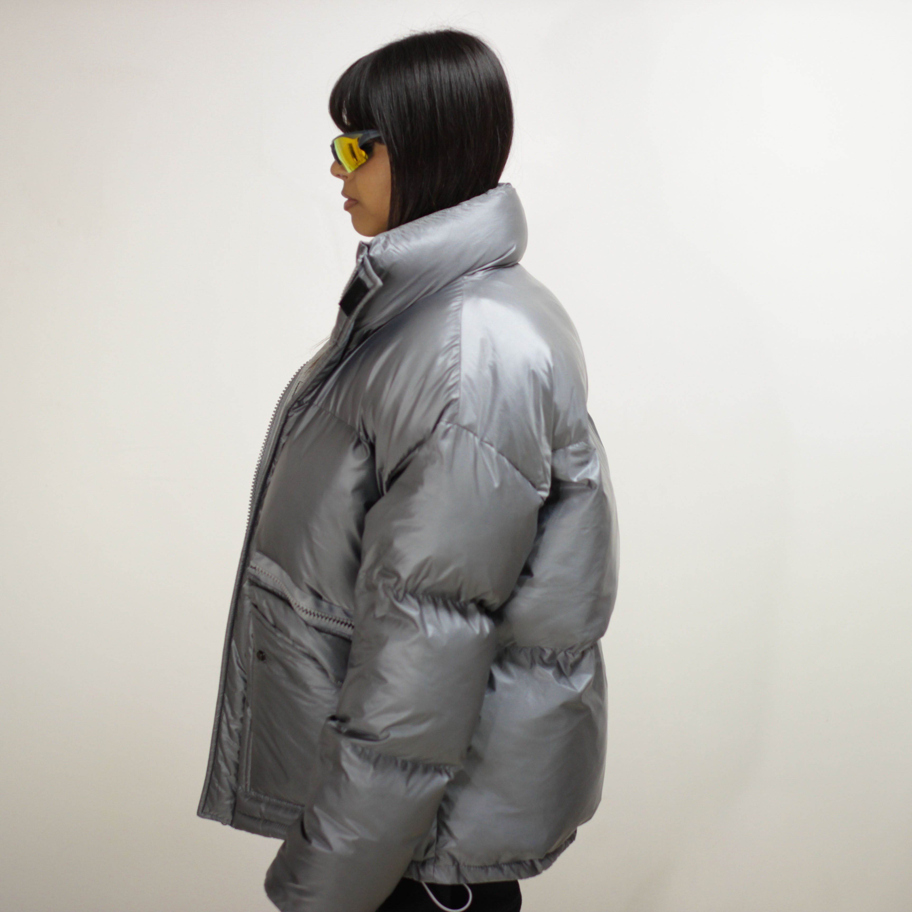 Side view of a silver padded round jacket on a model.