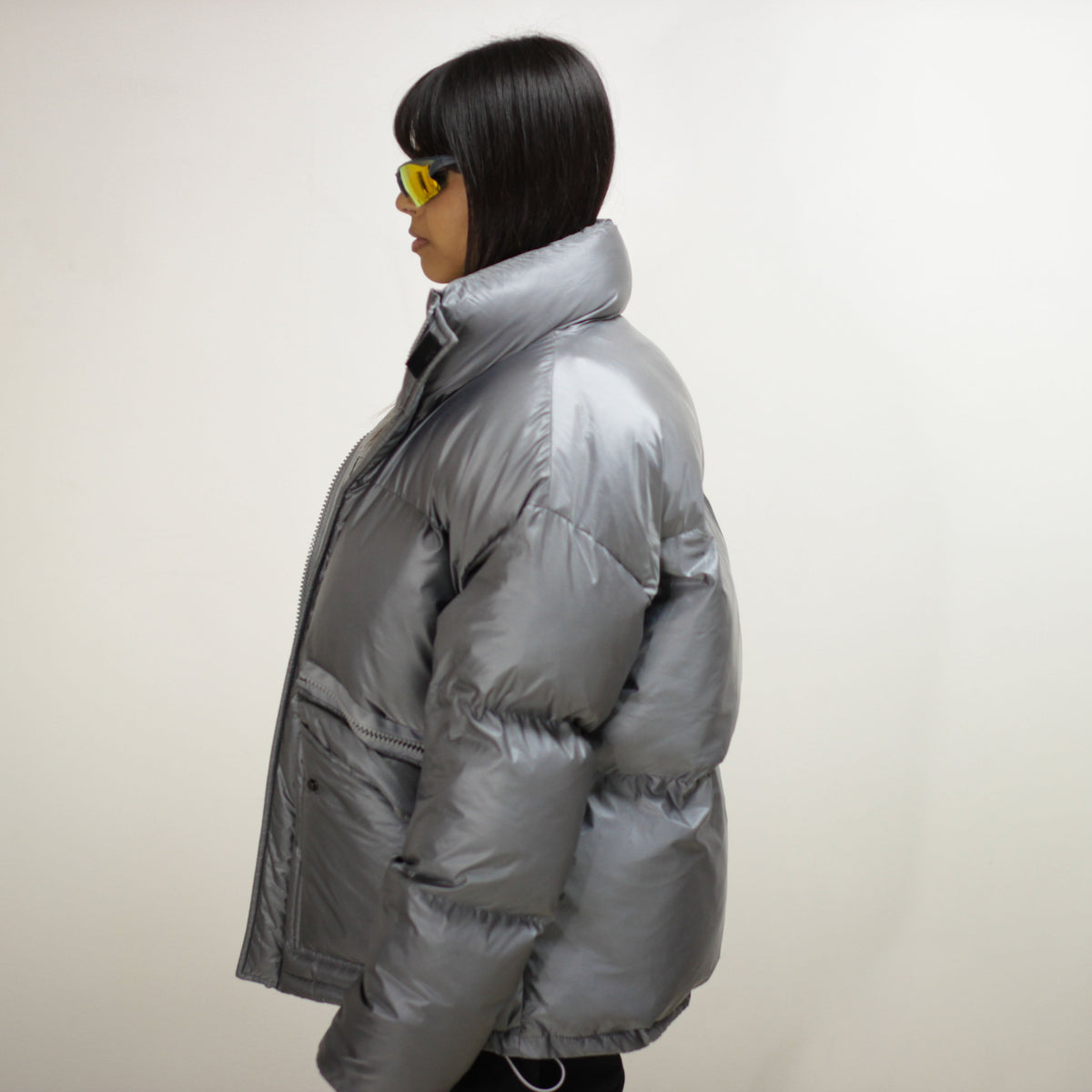 Side view of a silver padded round jacket on a model.