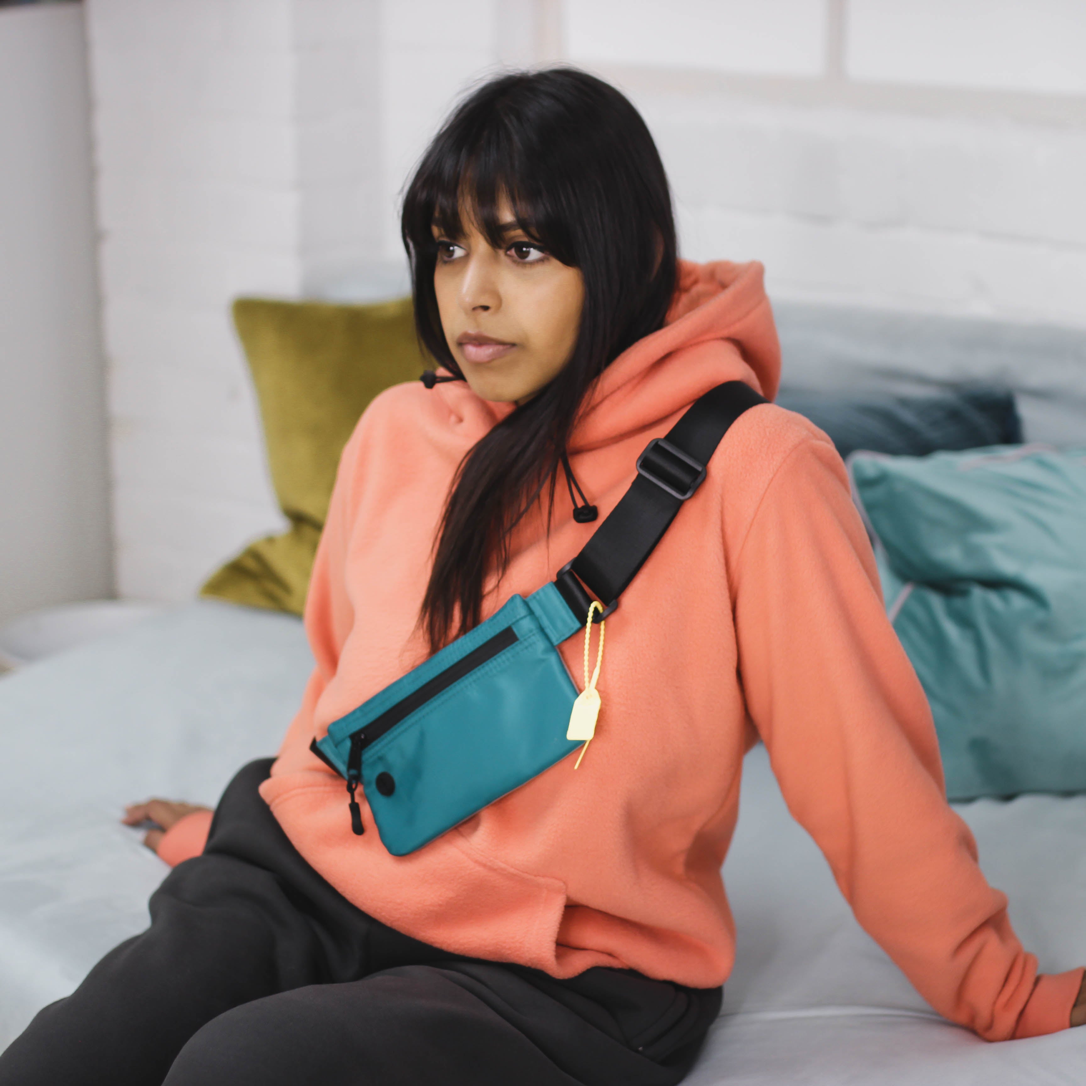 Woman wearing cozy peach hoodie sitting indoors.