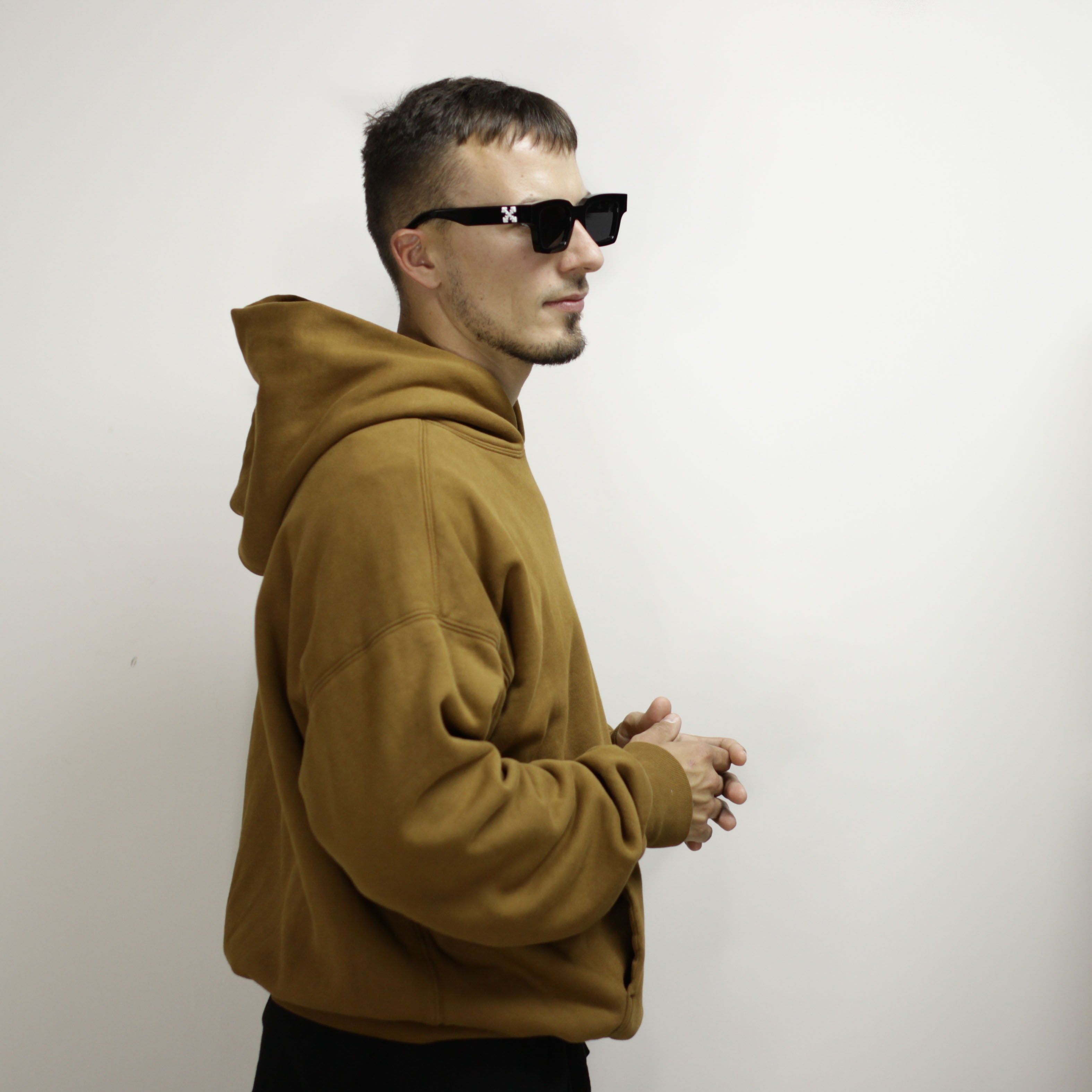 Man wearing a brown double layer hoodie and sunglasses.