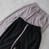 gray and black cotton draw string pant laid flat on floor