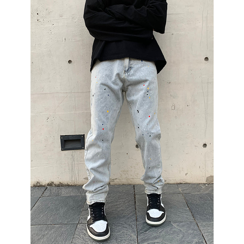 Light-blue denim jeans with paint splatter, offering a relaxed, distressed look.
