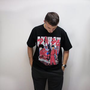 Model looking down wearing the Akira anime film inspired black t-shirt for streetwear fans wanting to pay homage