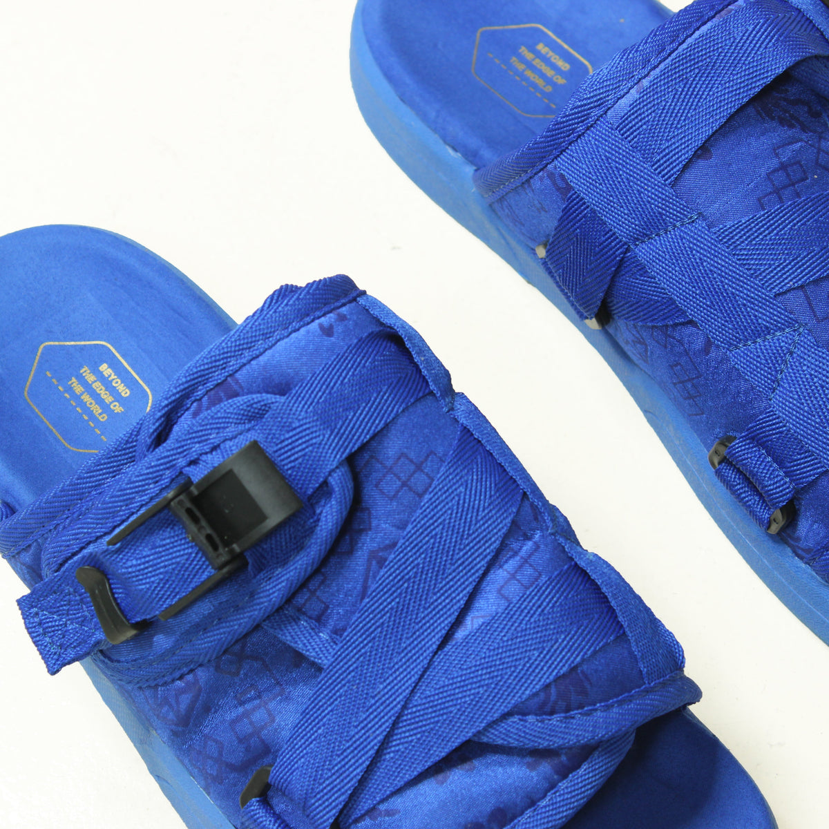 Cobalt blue slides with textured straps and buckle detail.