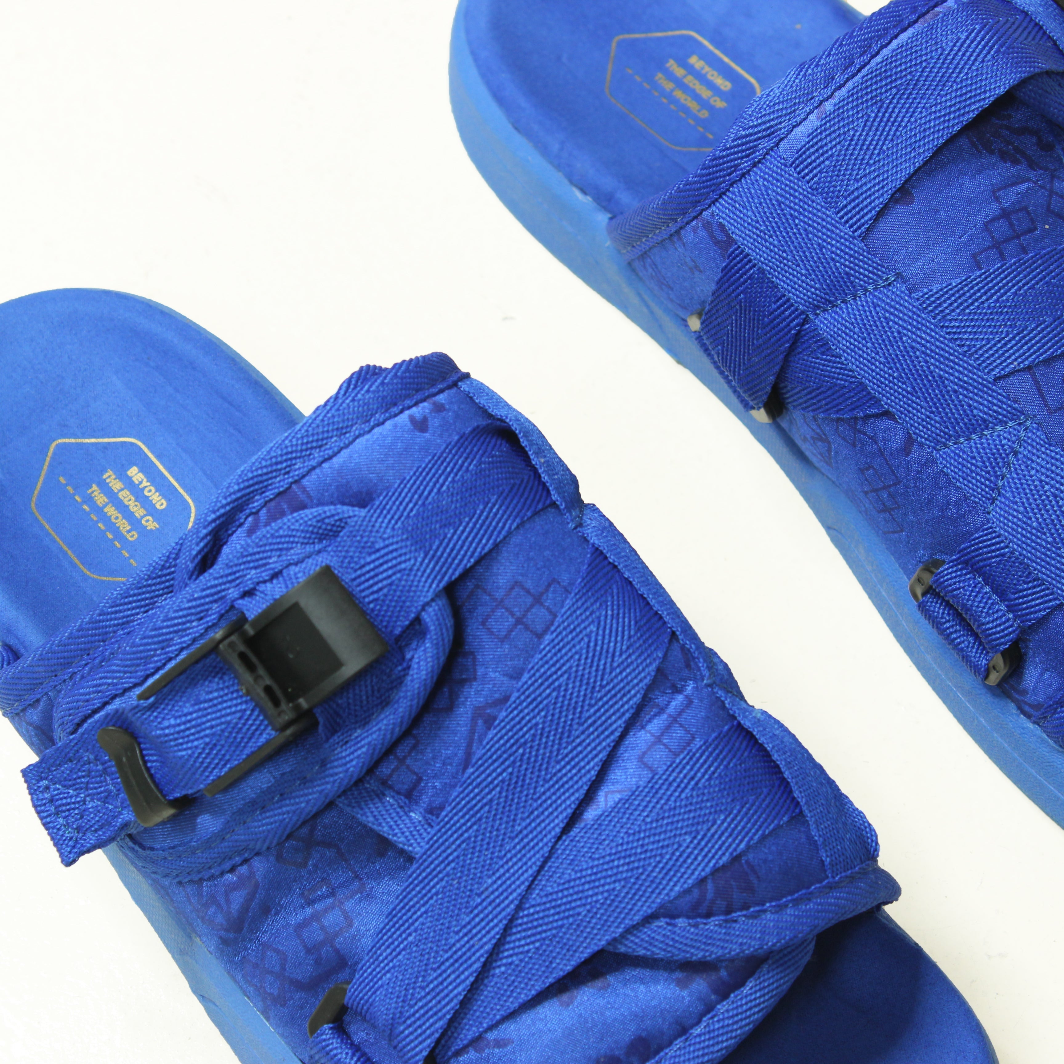 Cobalt blue slides with textured straps and buckle detail.