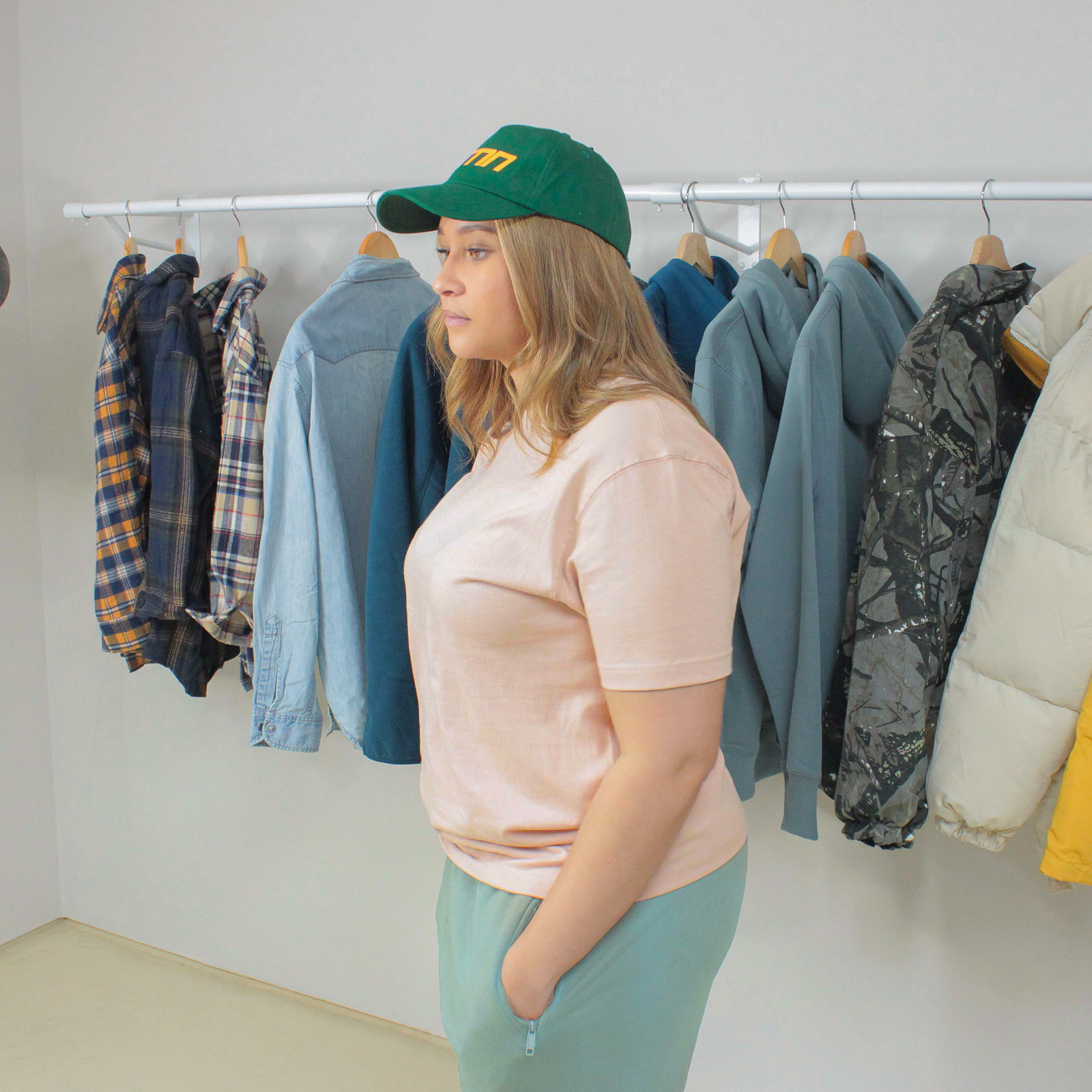 Woman wearing a Peach Winter Tee standing in front of a clothing rack.